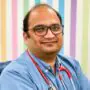 "Dr. Dharmanshu Chaube, pediatrician from Indore, wearing stethoscope and blue shirt, provides a positive testimonial about Xtrim Digitech’s digital marketing services"