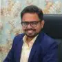 "Dr. Manoj Pawar, plastic surgeon in Pune, client of Xtrim Digitech, seated in office, providing Google review testimonial"